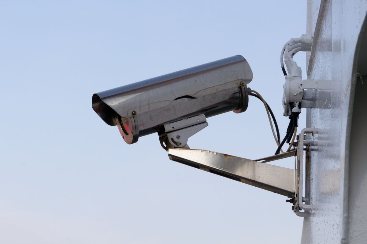 PoE security camera mounted on a commercial building exterior with ethernet cabling
